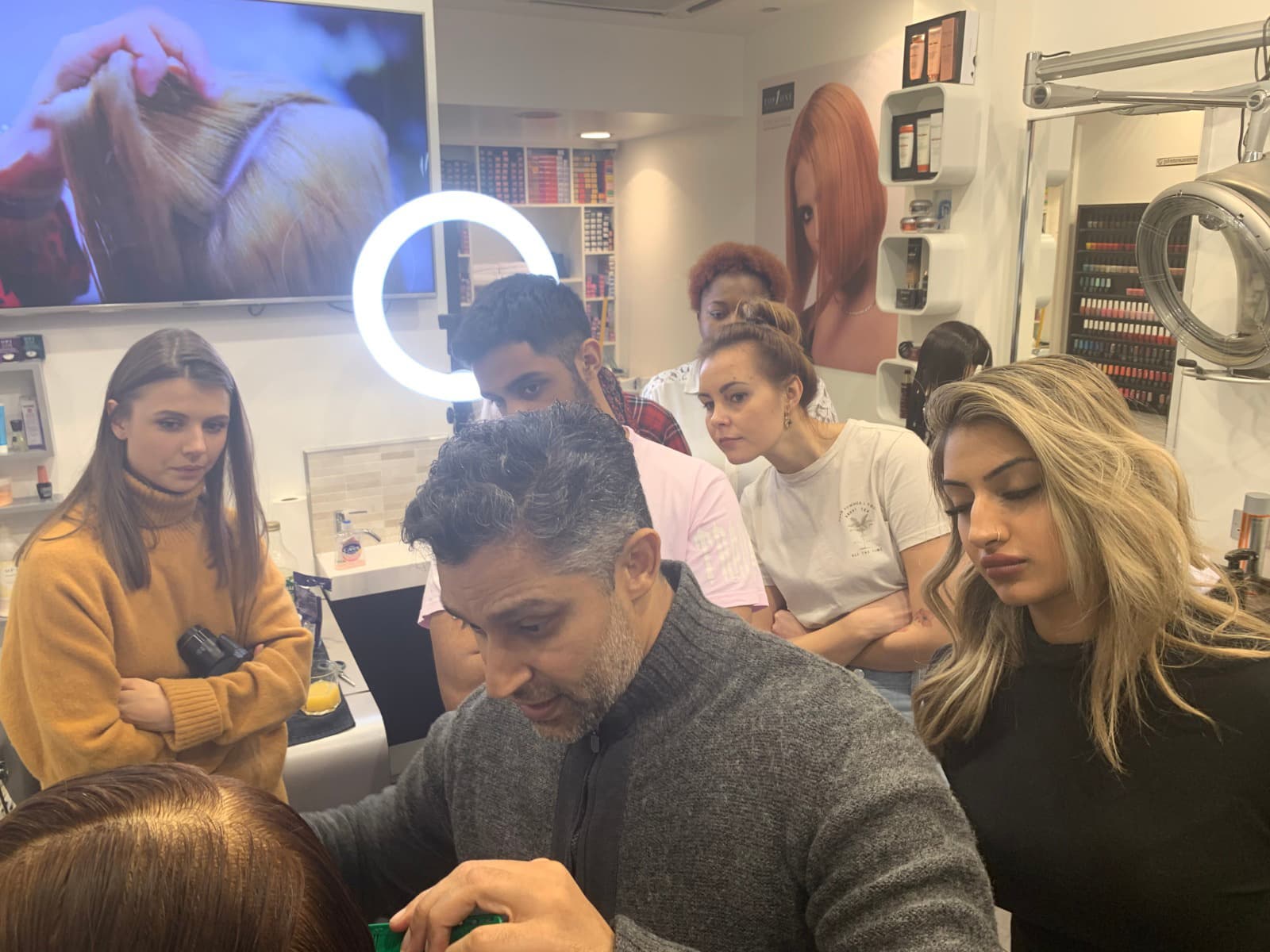 Director showing how to cut a bob for all employees